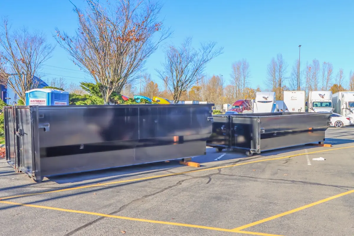 Professional dumpster rental service with roll-off container on residential driveway in Suffern